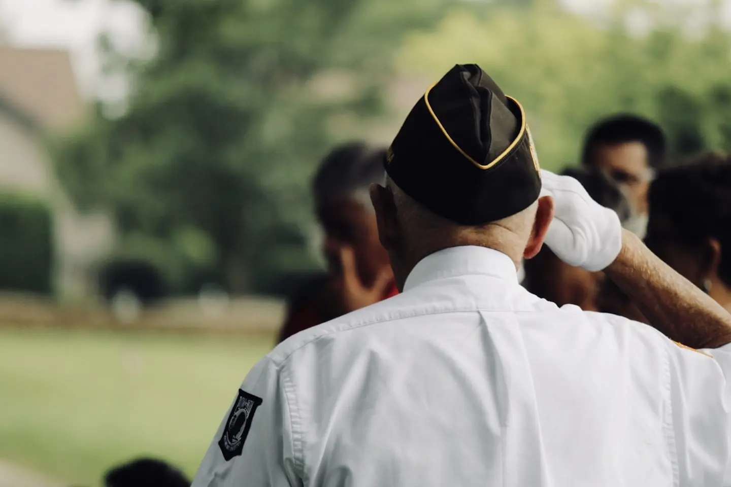Veteran in uniform saluting during a public gathering